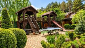 a garden with a wooden playground with a table at Дом на берегу 1dom club in Protsev