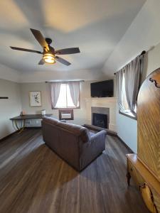 a living room with a couch and a ceiling fan at The Baker Hotel in Cranbrook