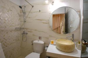 a bathroom with a toilet and a sink and a mirror at Corfu Spanos House in Sokraki in Sokrákion