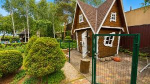 a small house with a gate in a yard at Дом на берегу 1dom club in Protsev +38 photos