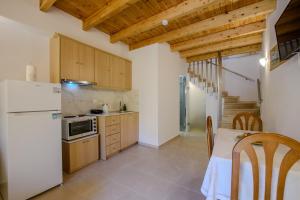 a kitchen with a white refrigerator and a table at Corfu Spanos House in Sokraki in Sokrákion +12 photos