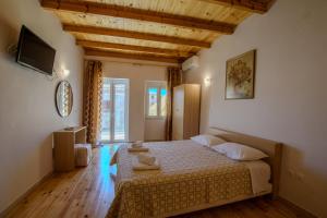 a bedroom with a large bed in a room with wooden floors at Corfu Spanos House in Sokraki in Sokrákion