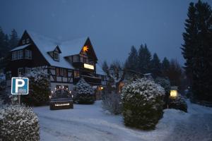 ein großes Haus mit Weihnachtslichtern im Schnee in der Unterkunft Helenenhof in Kurort Altenberg