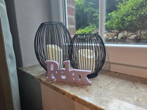 two black vases sitting on a counter next to a window at Haus Blume in Medebach