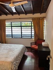 a bedroom with a bed and a window and a chair at Casa Kiwi Hostel in Medellín +55 photos