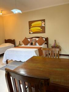 a bedroom with two beds and a painting of bananas at Pousada Banzay in Paraty
