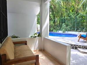 a living room with a couch and a swimming pool at Nosara Paradise Rentals in Nosara