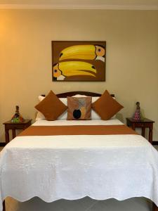 a bedroom with a bed with a painting of bananas at Pousada Banzay in Paraty