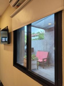 a window view of a patio with a pink chair at Hotel Alhambra in General Alvear