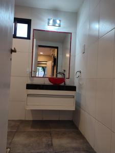 a bathroom with a red sink and a mirror at Hotel Alhambra in General Alvear