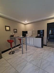 a room with a kitchen with a counter and stools at Hotel Alhambra in General Alvear +1 photo