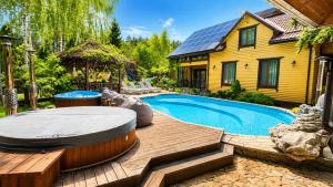 a backyard with a swimming pool and a house at Дом на берегу 1dom club in Protsev