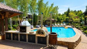 a backyard with a swimming pool with a grill and a swimming pool at Дом на берегу 1dom club in Protsev