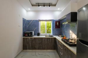 a kitchen with wooden cabinets and a window in it at Luxury Haven Stay in Noida