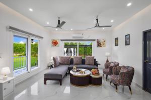 a living room with a couch and chairs and a table at Luxury Haven Stay in Noida