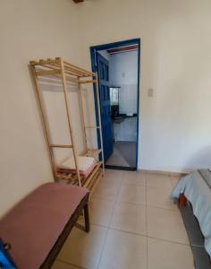 a room with a bed and a room with a ladder at Chalé Refúgio Casarão in Passa Quatro