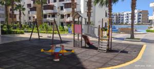 a playground with a toy airplane on a swing at Les dunes de martil familles in Martil