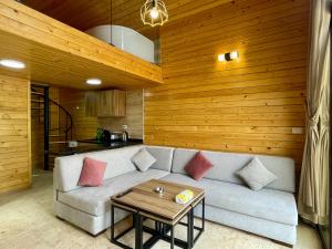 a living room with a couch and a table at Les Pavillons D'Ehden in Ehden
