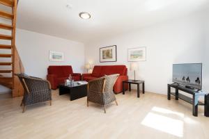 a living room with a red couch and chairs at Gut Staberhof Staberholz in Staberdorf