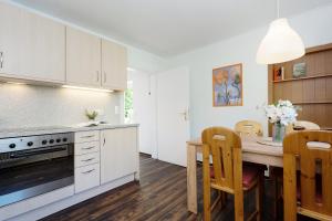 a kitchen with white cabinets and a table with chairs at Gut Staberhof Staberholz in Staberdorf