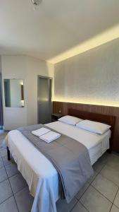 a bedroom with two beds with towels on them at Pousada Village in Florianópolis +13 photos