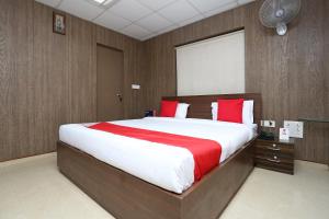 a bedroom with a large bed with red pillows at Hotel O Kalinga Regency in Khandagiri