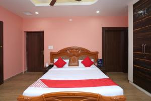 a bedroom with a large bed with red pillows at Hotel O Kalinga Regency in Khandagiri +15 photos