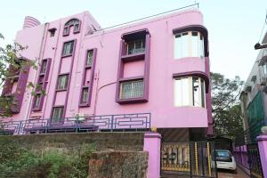 a pink house with a fence in front of it at Hotel O Kalinga Regency in Khandagiri