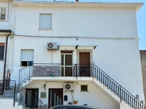 a white building with stairs and a balcony at APT Via Calabria 6da Francesca in Marina di Monasterace