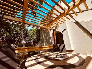 a patio with a wooden pergola and a table at Blues House in Venus