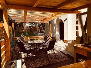 a patio with a table and chairs under a wooden pergola at Blues House in Venus