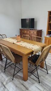 a dining room table with chairs and a television at La Candela in Olavarría