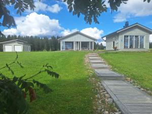 a house with a walkway in front of a yard at Paris Beach in Saarijärvi