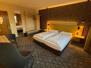 a bedroom with a large bed and a chair at Hotel Felsenkeller in Rüdesheim am Rhein +81 photos