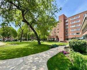 a park with a tree and a building at The GEM Museum Suites in Evanston
