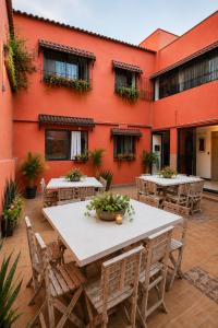 a patio with tables and chairs in front of a building at Morada Luna Coyoacán in Mexico City