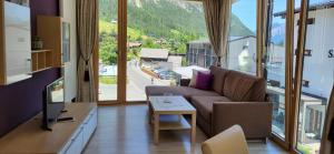 a living room with a couch and a large window at Aparthotel Bergkristall in Brand