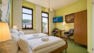 a hotel room with a bed with towels on it at YFB Frühstückspension Weiße Rose I Zentral gelegen in Bad Elster