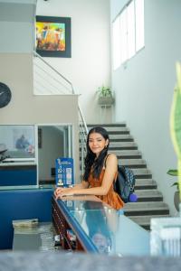 a woman sitting at a counter in a staircase at Hotel Tropical in Corozal