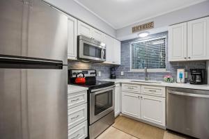 a kitchen with white cabinets and stainless steel appliances at 8A Amelia Landings Condo in Fernandina Beach