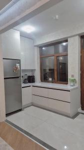 a kitchen with white cabinets and a stainless steel refrigerator at Jasmin Park in Baku
