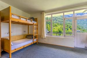 a bedroom with bunk beds and a large window at La Heim Hostels in Manāli
