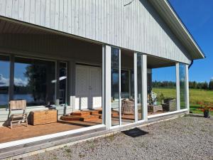 a screened in porch of a house with a chair at Paris Beach in Saarijärvi