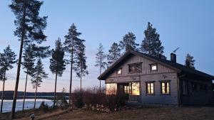 a small house with lights on in a forest at Mökki järven rannalla, Matkailukartano Kivennapa in Pieksänkoski
