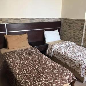 two beds sitting next to each other in a room at Astana in Sowayma