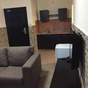 a living room with a couch and a kitchen at Astana in Sowayma