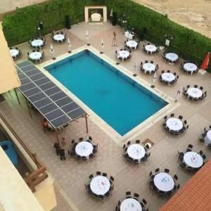 an overhead view of a swimming pool with tables and chairs at Astana in Sowayma