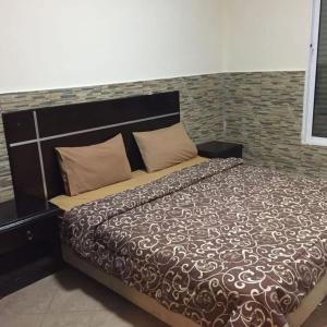 a large bed in a bedroom with a brick wall at Astana in Sowayma