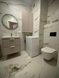 a white bathroom with a toilet and a mirror at Kaszmirowy Apartament in Mrągowo +11 photos