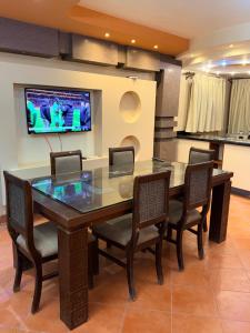 a dining room table with chairs and a tv on a wall at Porto Sokhna Penthouse with Private Pool - MR in Ain Sokhna